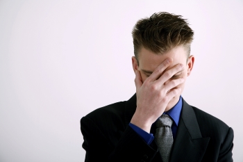 Man dealing with memory loss covering his eyes in frustration