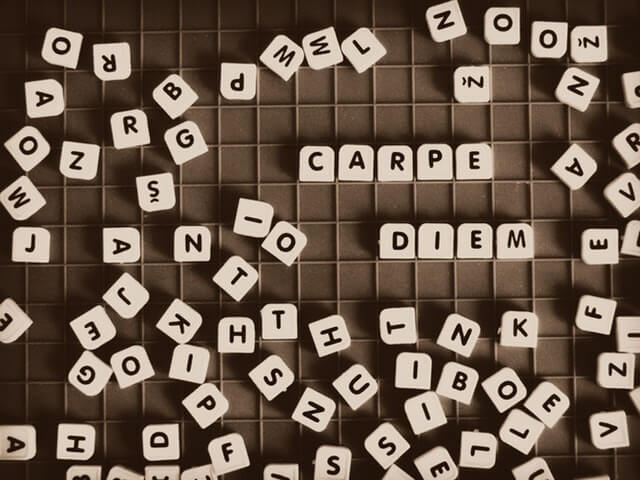 Bild von Scrabble-Buchstaben, die Carpe Diem sagen, um die Notwendigkeit auszudrücken, jetzt mit dem Auswendiglernen von Vokabeln zu handeln