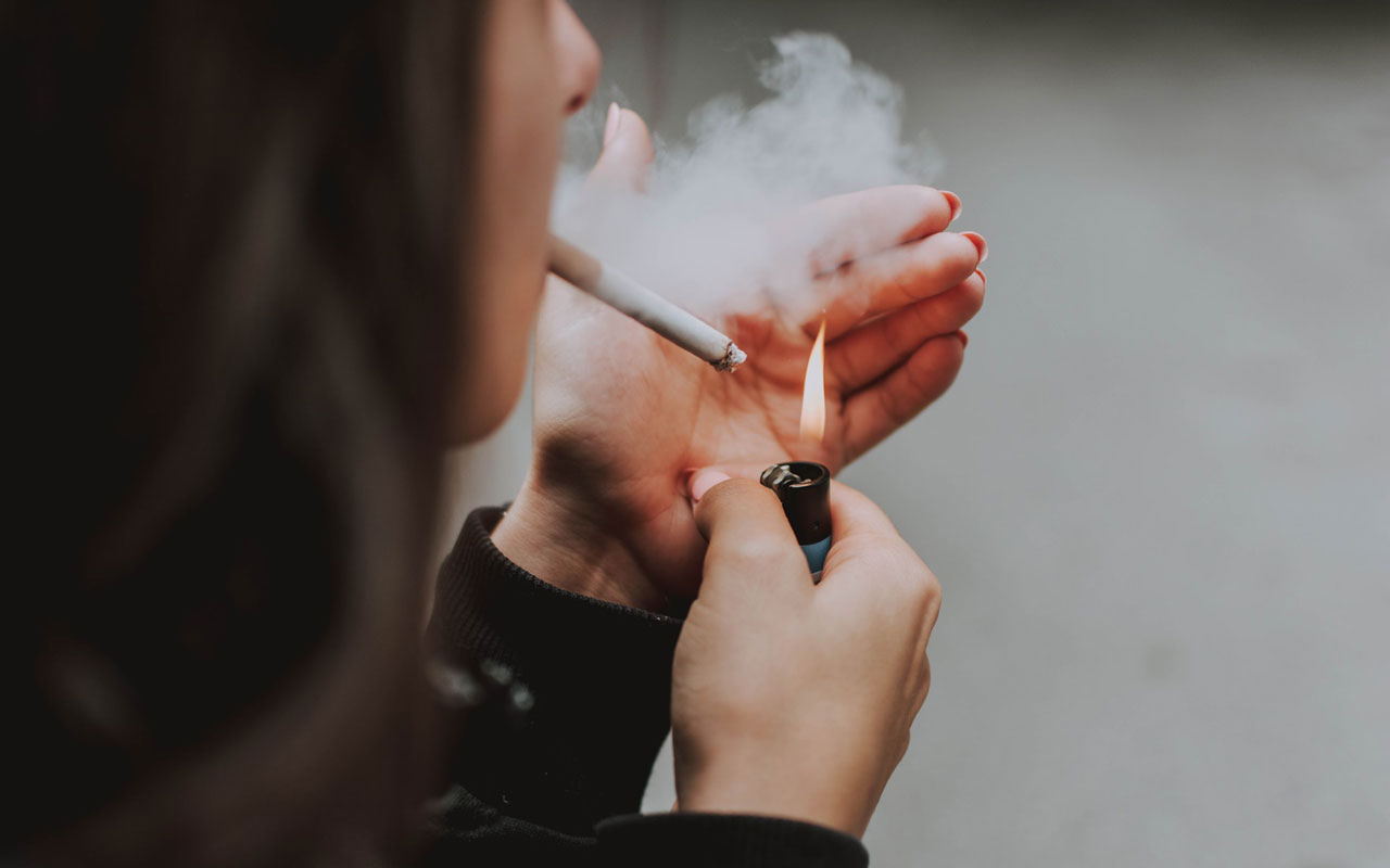A woman lighting a cigarette. Classical conditioning might be useful to modify a chain smoker's habit.