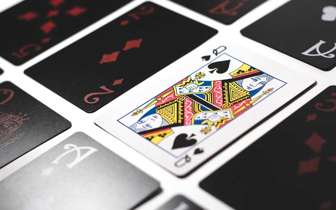 Cards on a table, with the Queen of Spades face up.