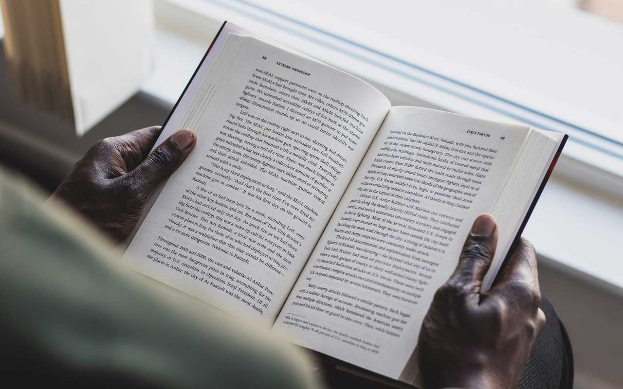 A person holding a book. A type of cognitive activity would be counting the number of times the letter E appears on the pages.