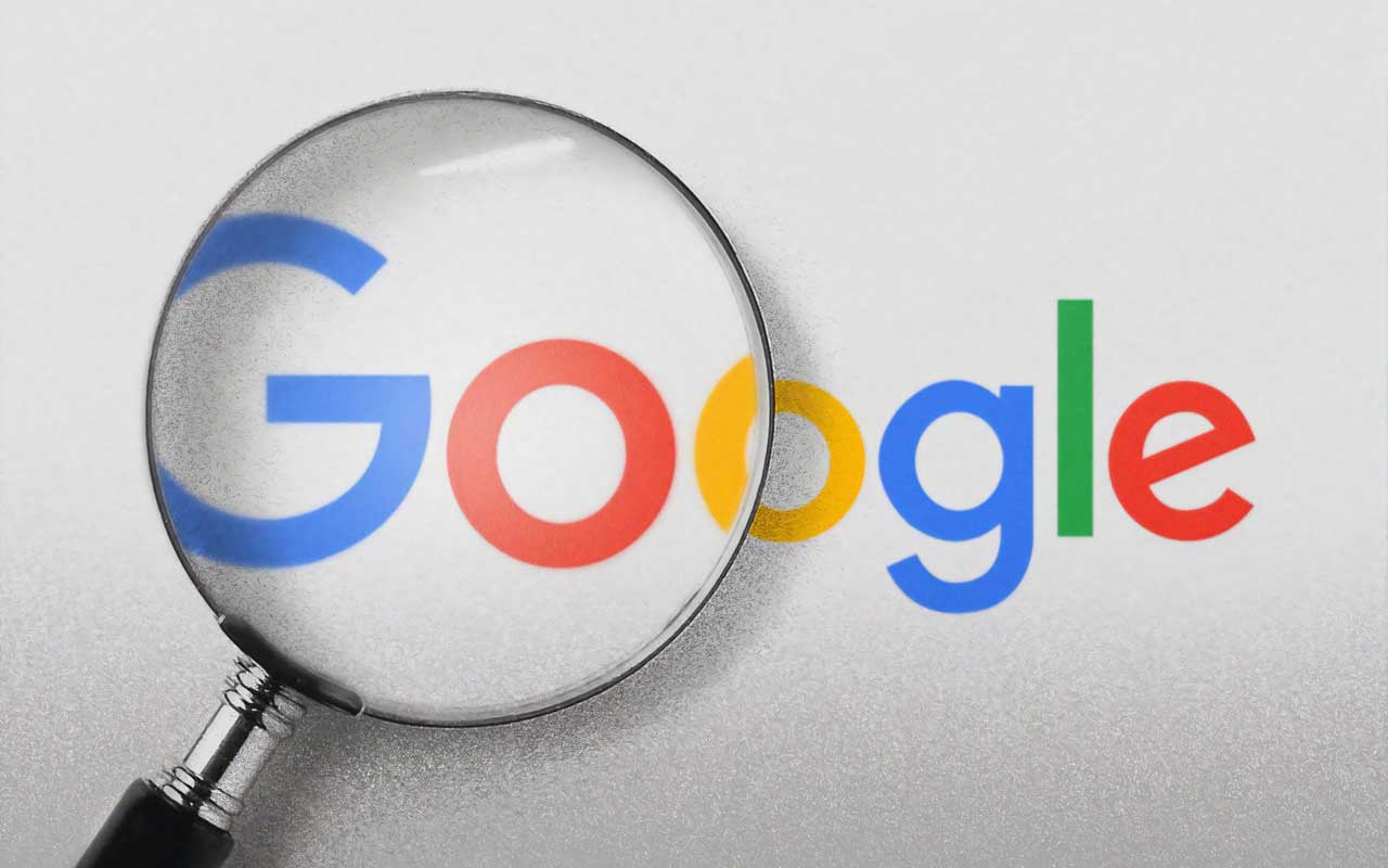 The Google logo under a magnifying glass. Using search engines to answer questions for us created learned helplessness.