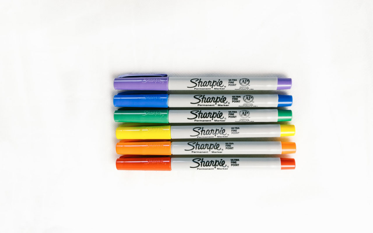 A stack of rainbow colored Sharpies. Tools like colored markers may help keep you organized and focused on studies.