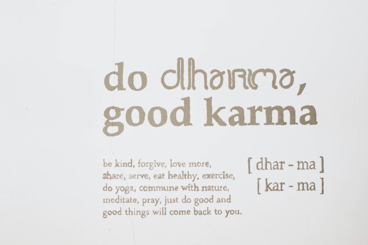 A painted sign stating "do dharma, good karma."