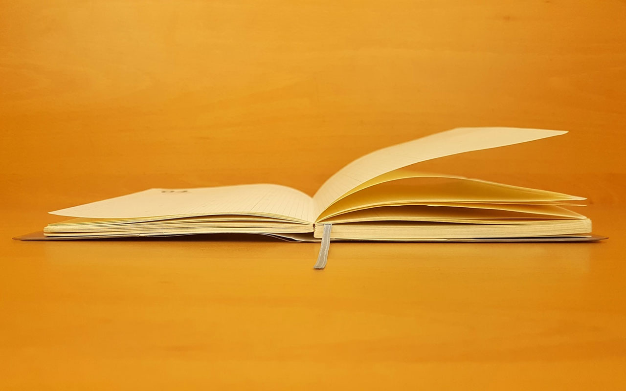 An open book against a yellow background.