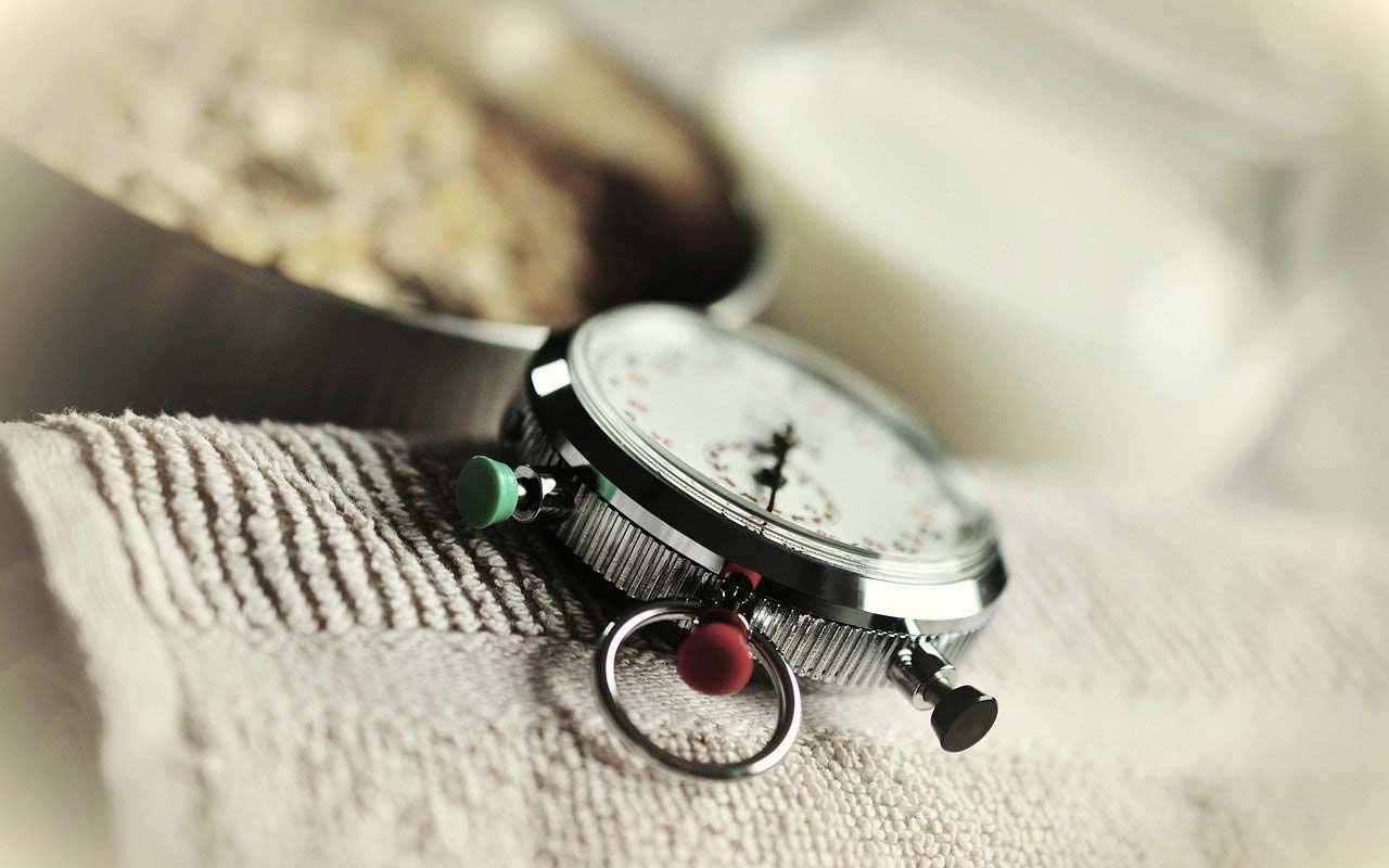 A manual stopwatch sits on a towel.