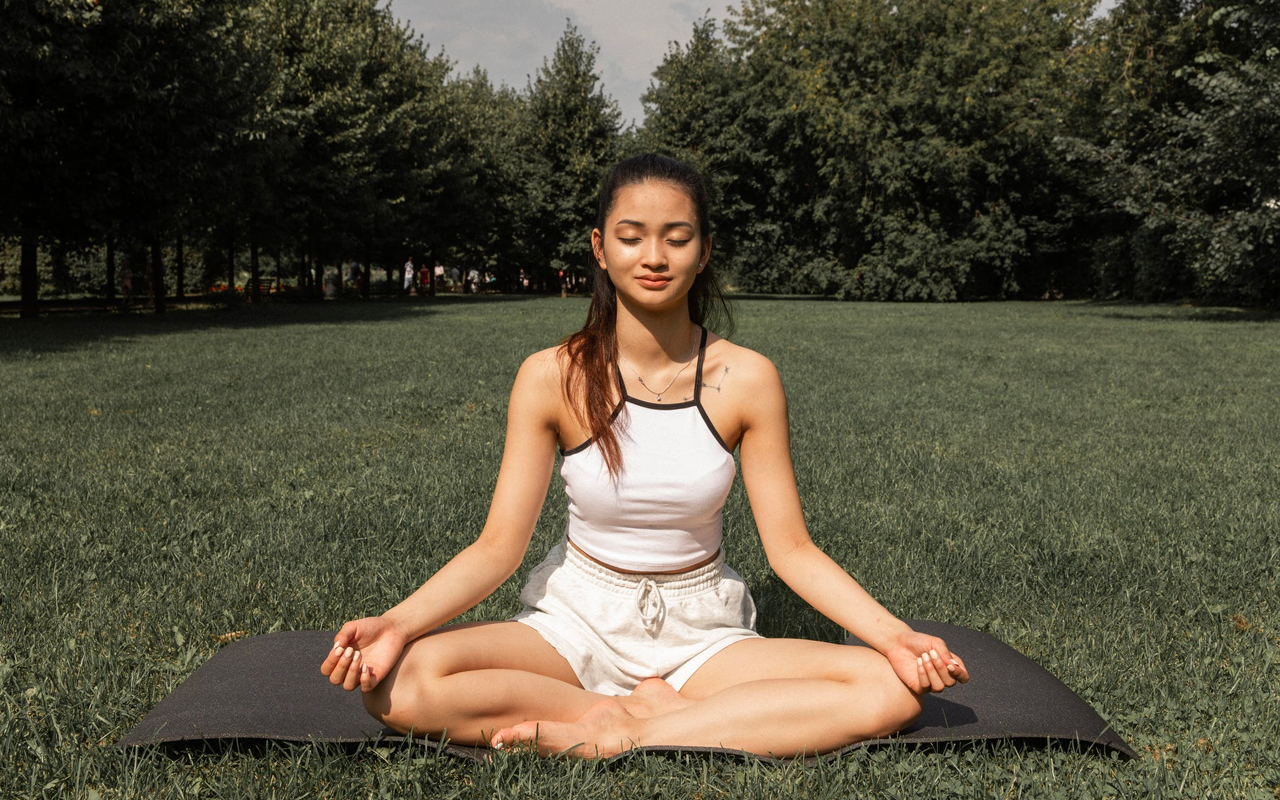 a women is meditating in a park