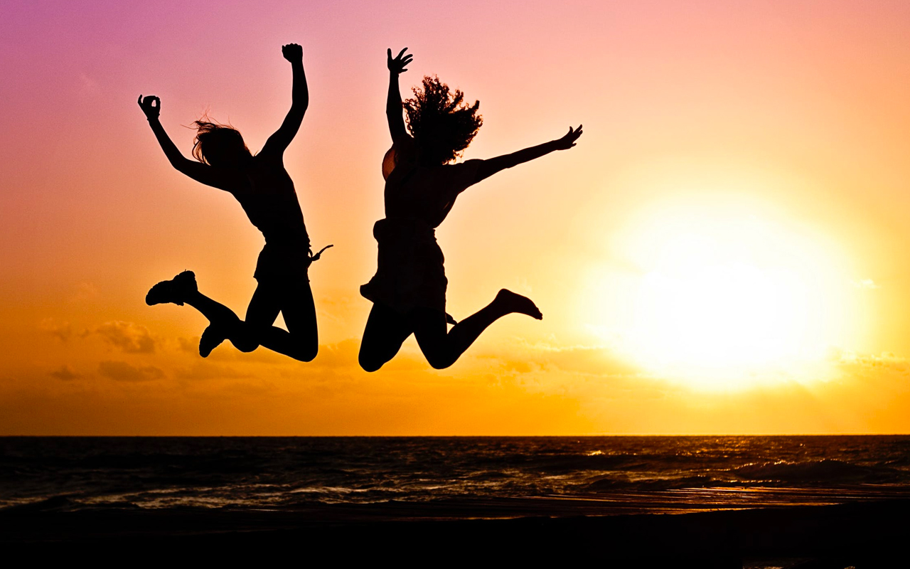 people jumping for joy on a beach