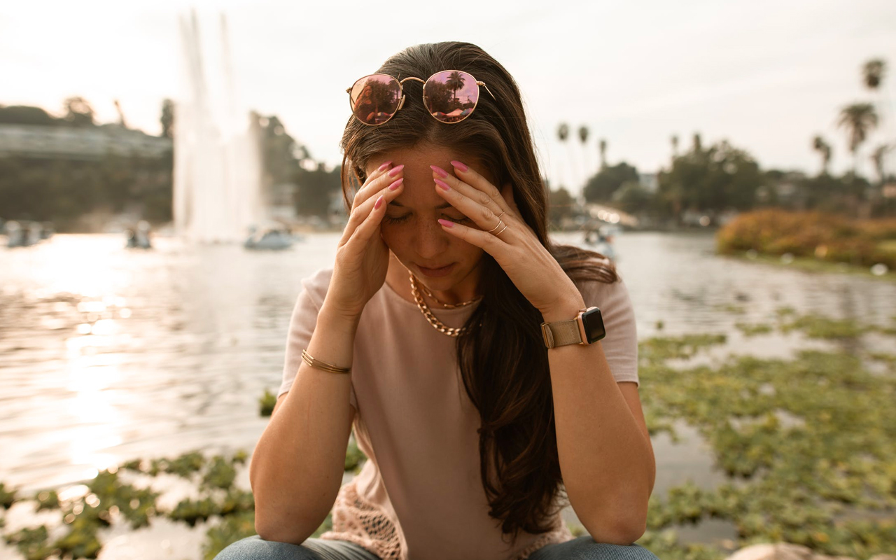 a women holds her hands in her head while suffering