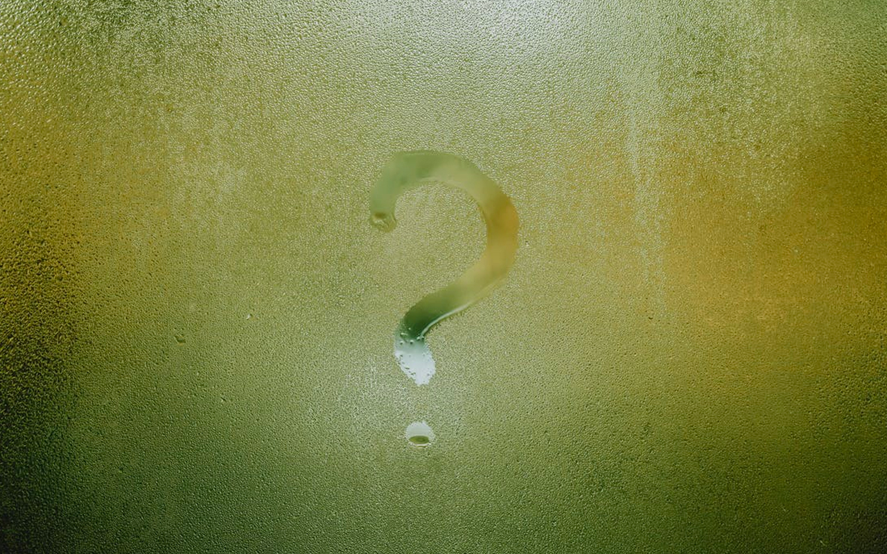 a frosted window with a question mark streaked on it