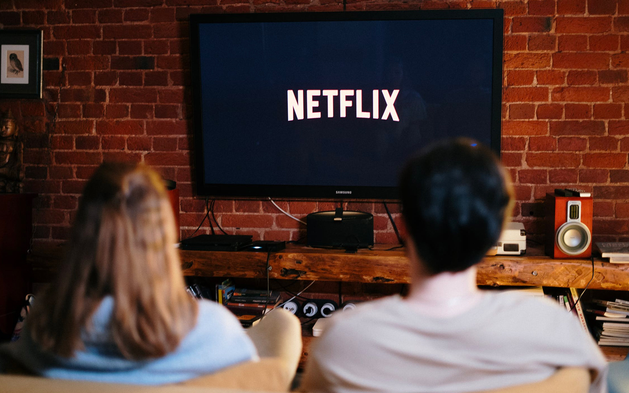 a man and a woman are watching movies together