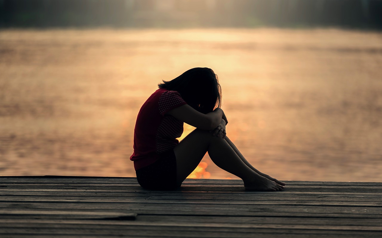 a woman is not happy sitting beside a beach