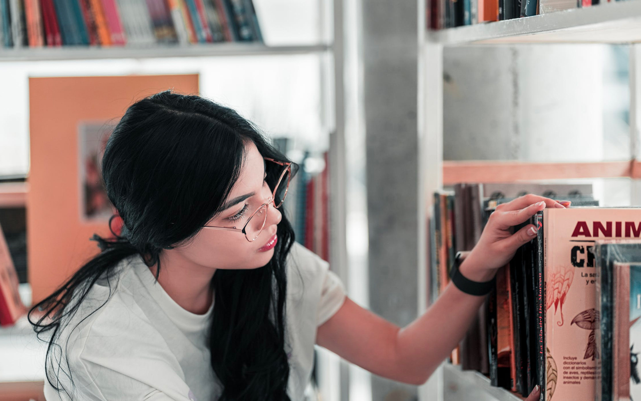 a woman is choosing a book