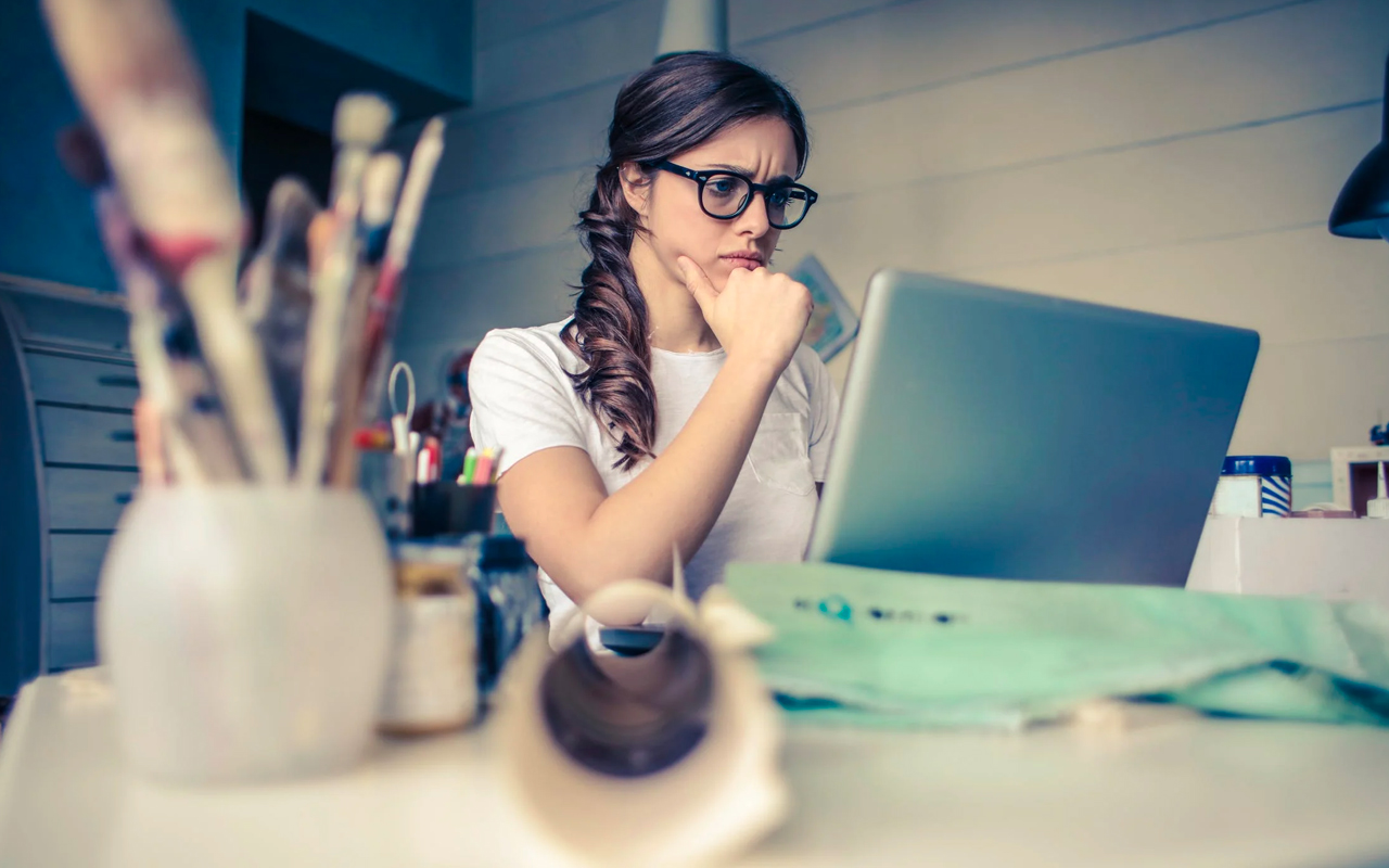 a woman is looking at her laptop
