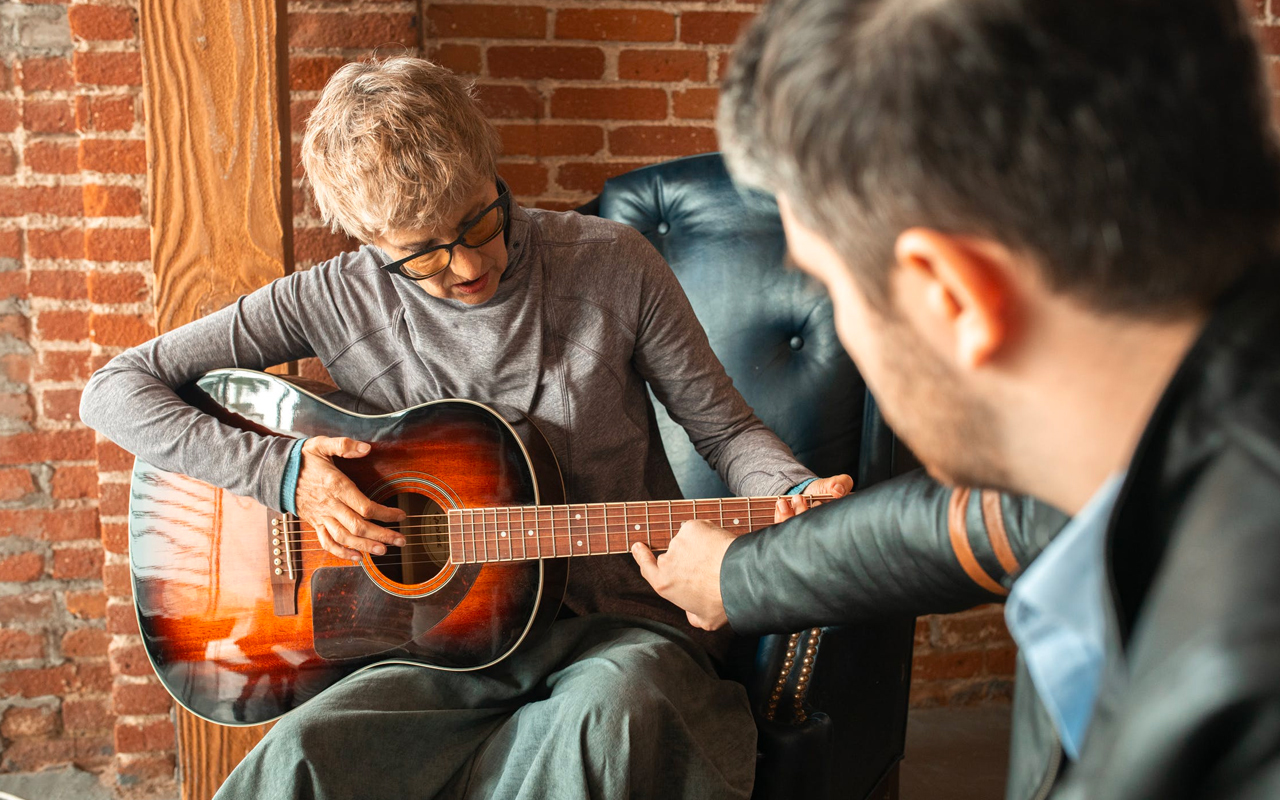 an old lady is learning guitar