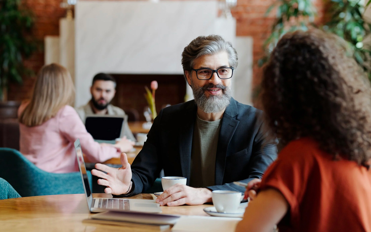 a beard man is talking with a woman