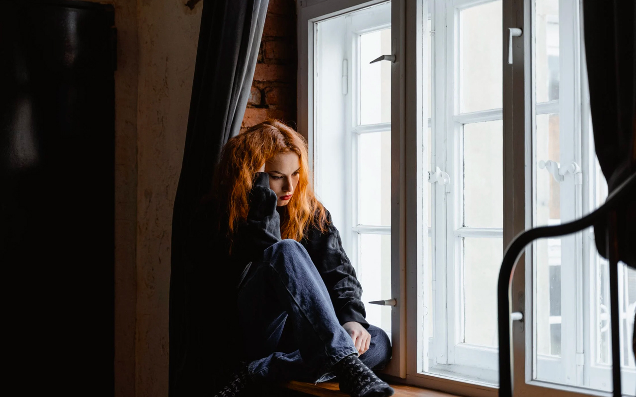 mental exhaustion woman beside the window