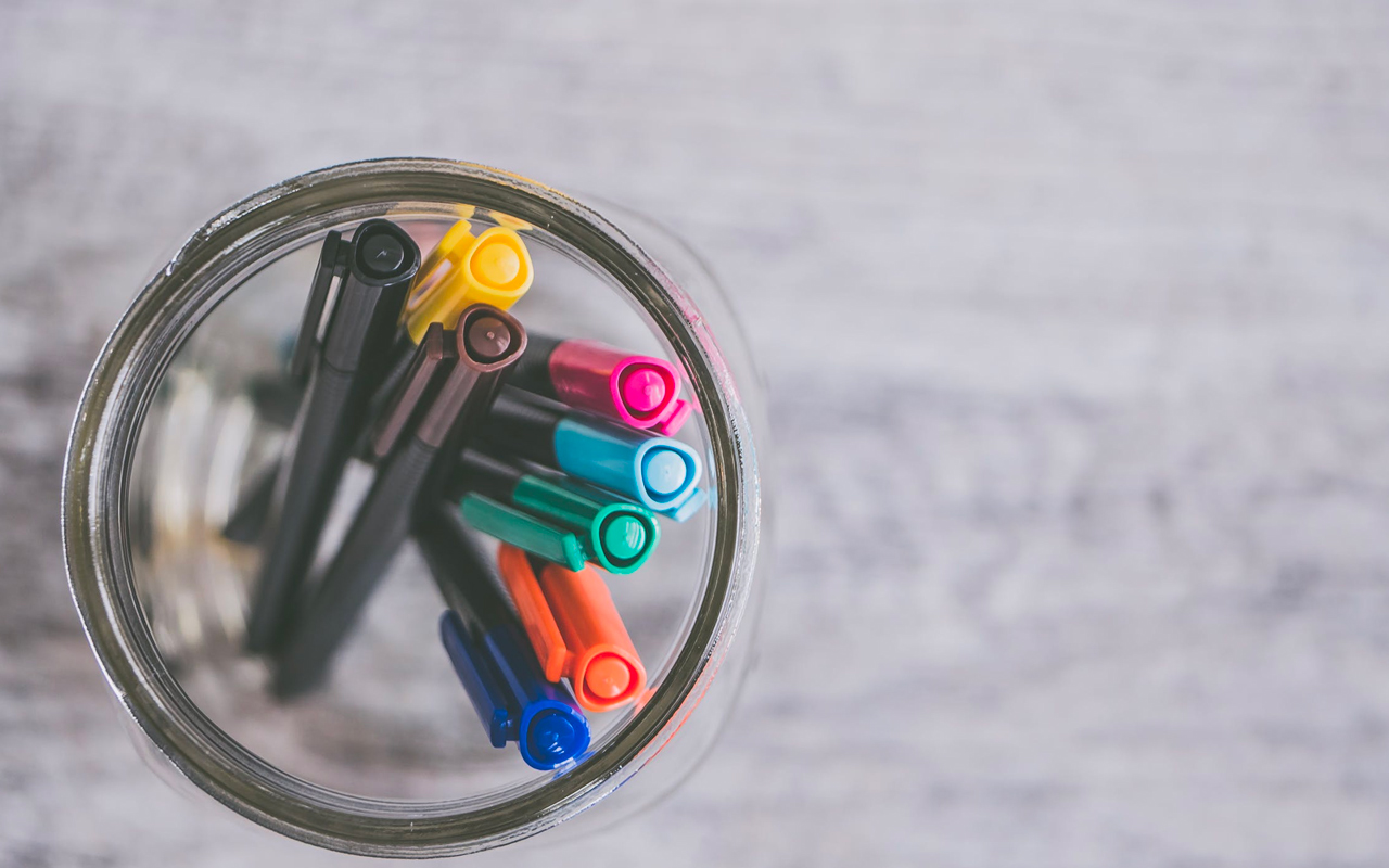 color pens in a glass jar