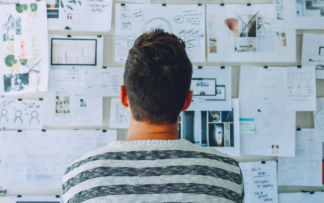 a man is thinking problems in front of a board