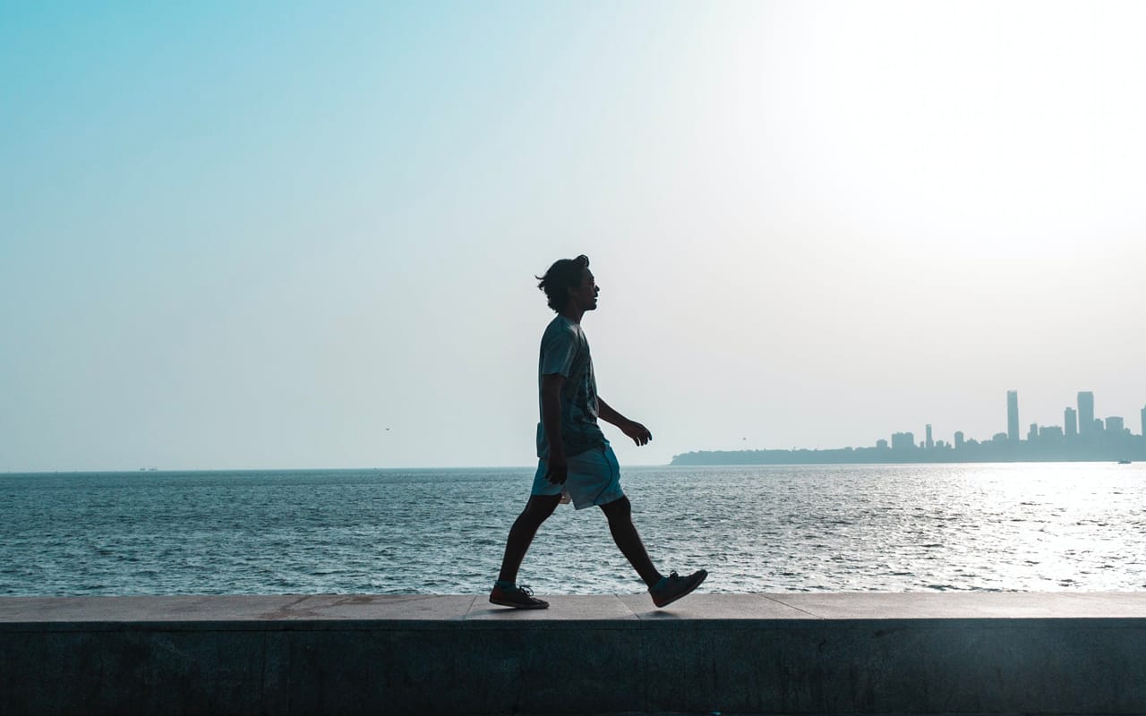 a man is walking around near the ocean