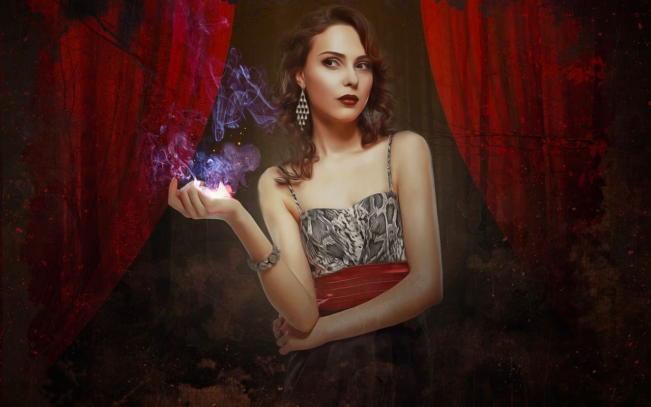 beautiful magician performing in front of a red background