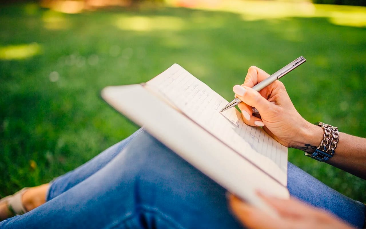 sitting on grass and writing