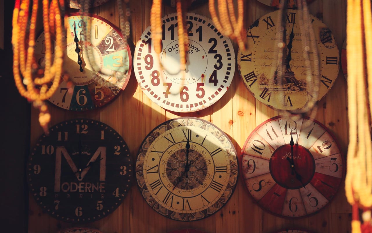 six clocks on a wooden wall