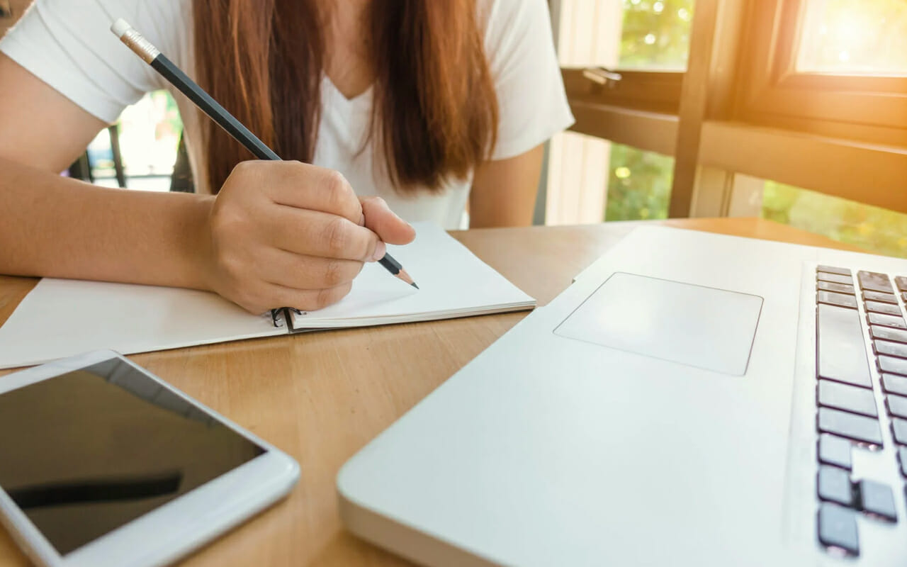 a woman is going to write with a pencil