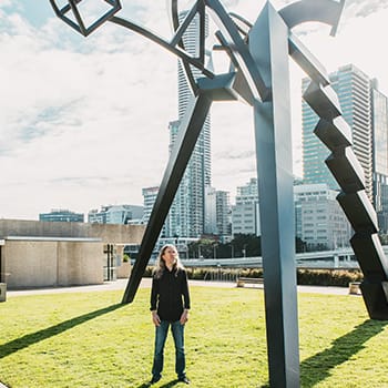 Anthony Metivier looking at a dynamic statue in Brisbane to express a concept related to cognitive training