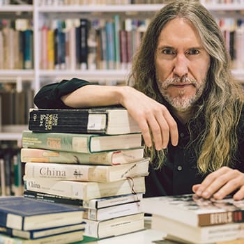 Lifelong learning feature image with Anthony Metivier in a library with books