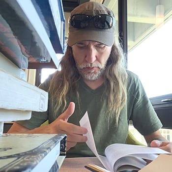 Anthony Metivier reading in a library